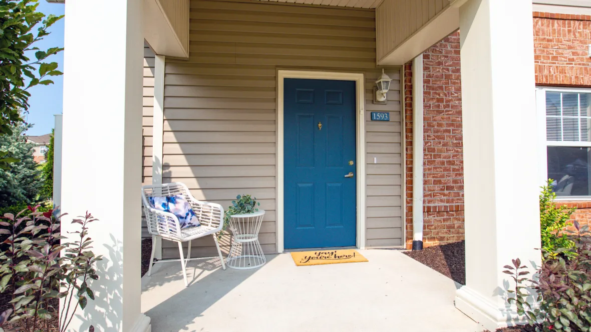 A capacious private patio adorned with an inviting blue door and room for outdoor furnishings.