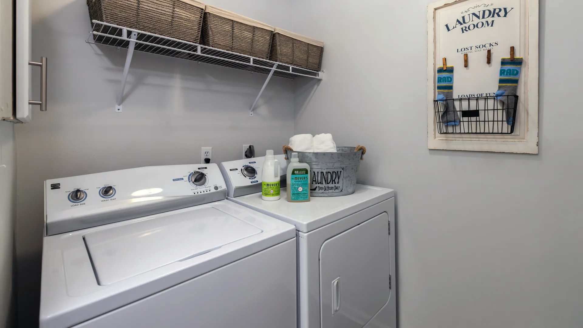 a full size, side-by-side washer and dryer with shelving above.