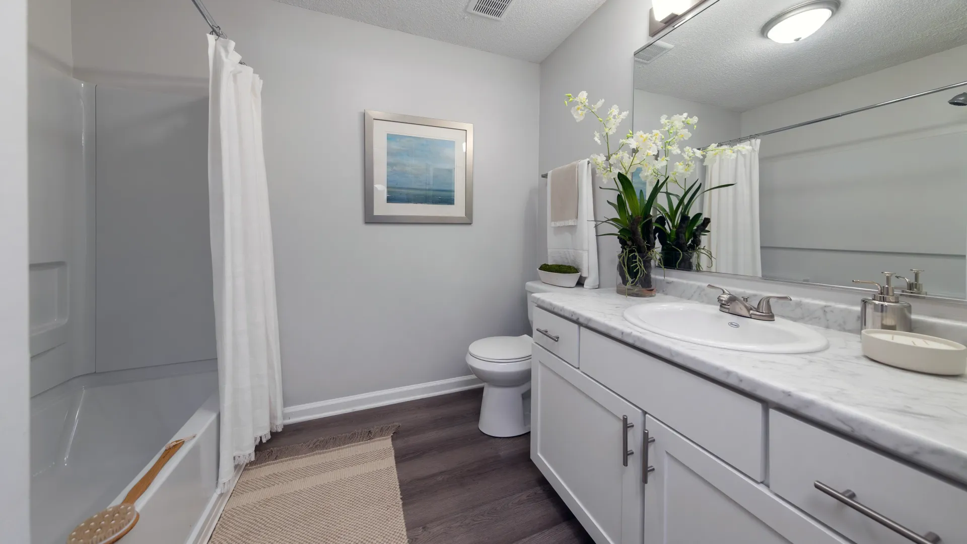 A bathroom with a focus on the sink, large mirror, and window above the towel rack