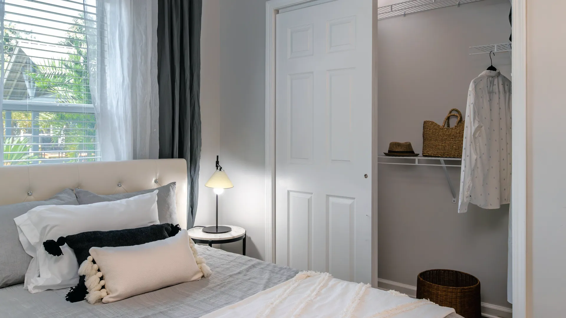 A bed adjacent to a spacious closet with staggered shelving.