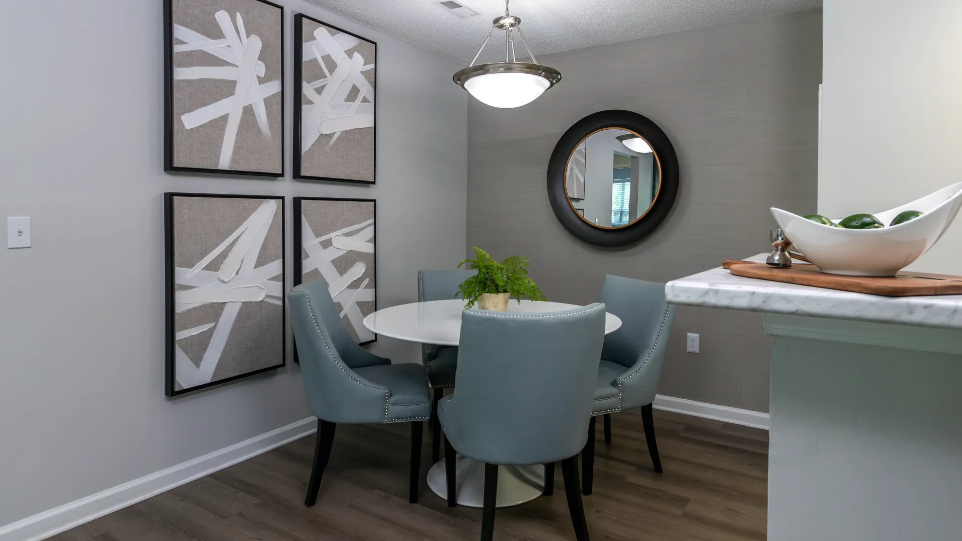 A dining room featuring a table with four chairs and built-in lighting.