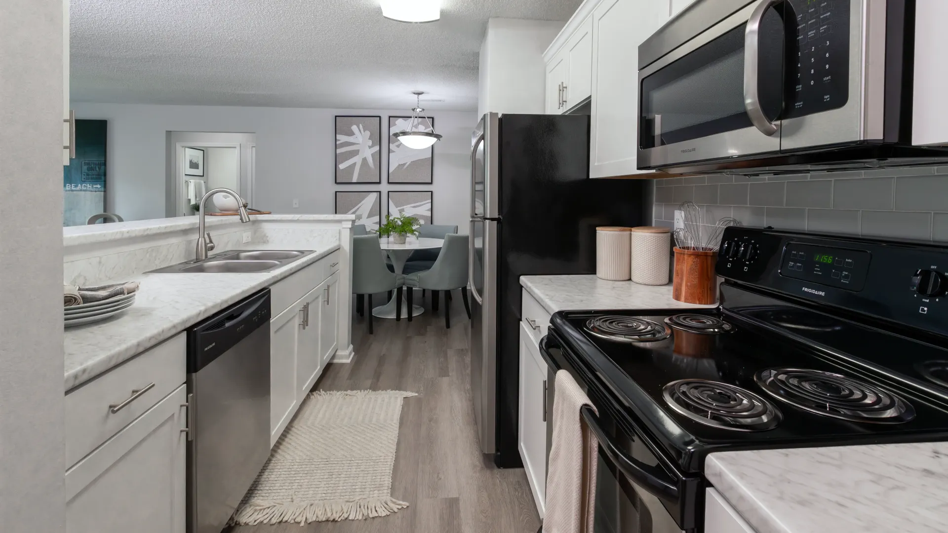 A galley-style kitchen with stainless-steel appliances and Carrara-style countertops.