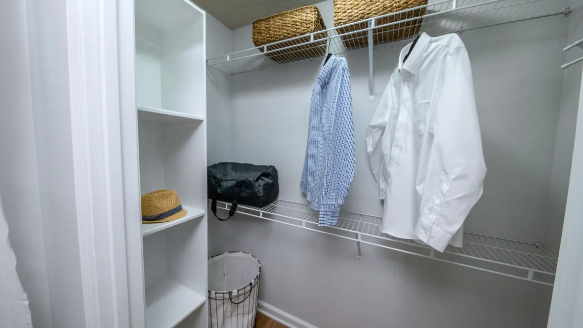 Interior of a walk-in closet at Emerson Isles showcasing staggered shelving and a floor-to-ceiling built-in shoe rack.