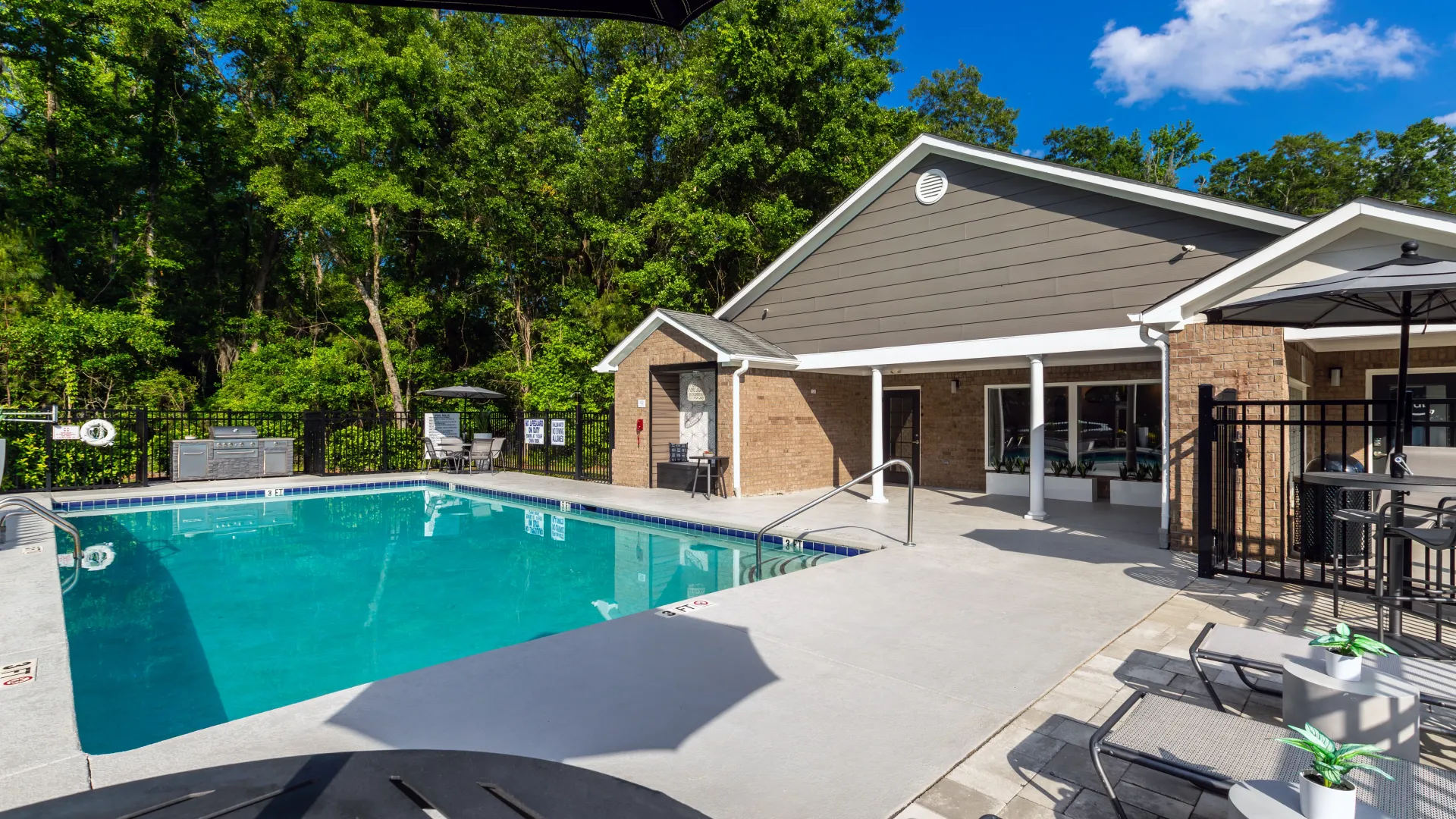 A pool surrounded by ample loungers and tables with umbrellas