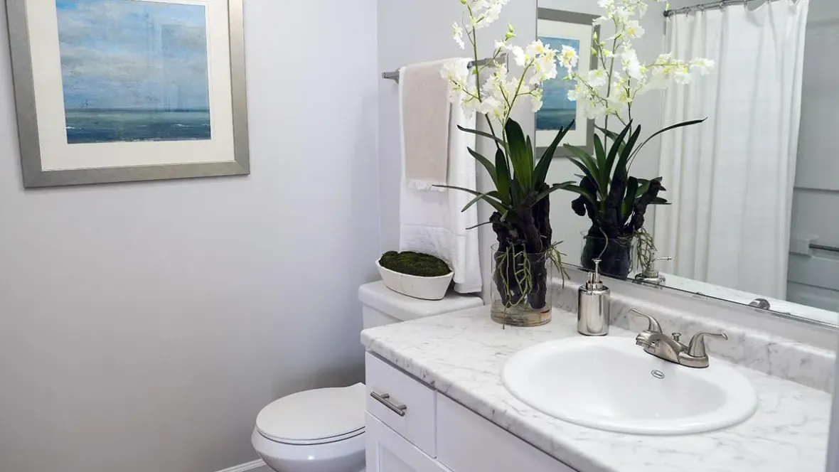 Brand-new designed restroom features include pristine white cabinetry and matching White Carrara countertops along with a grand mirror enhancing the bathroom’s aesthetic appeal.
