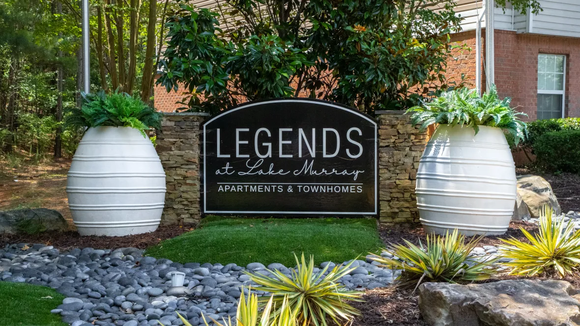 The Legends at Lake Murray front entry monument signage flanked by two large decorative planters with detailed landscaping surrounding for a bold feel. 