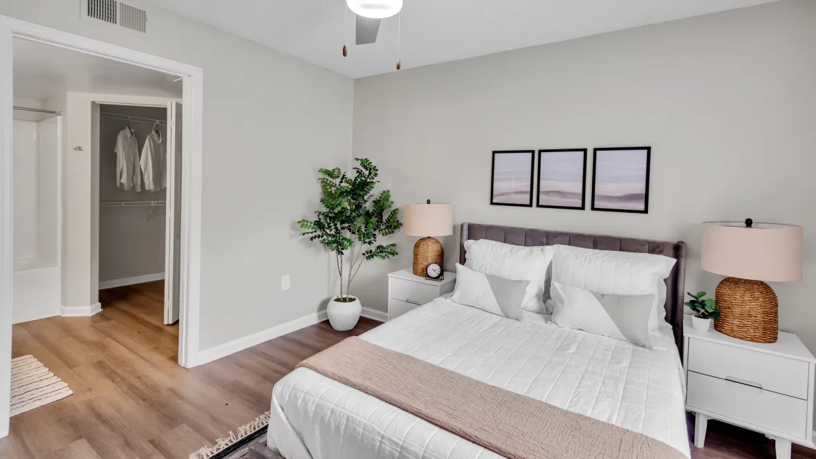 An expansive master suite with an overhead modern ceiling fan, an adjoining bathroom, and an extra linen closet for added storage.