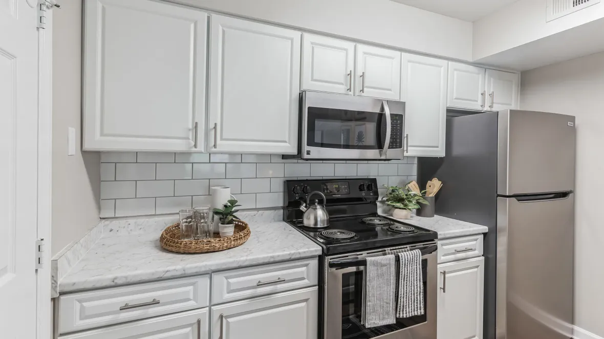 A kitchen equipped with stainless-steel appliances, a gleaming white color scheme, and a full appliance package for effortless cooking and cleaning.