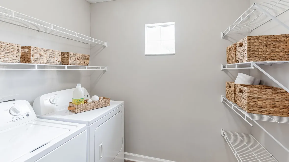 Spacious laundry room with laundry appliances and abundant shelving with brilliant natural lighting, designed for the utmost convenience and comfort.