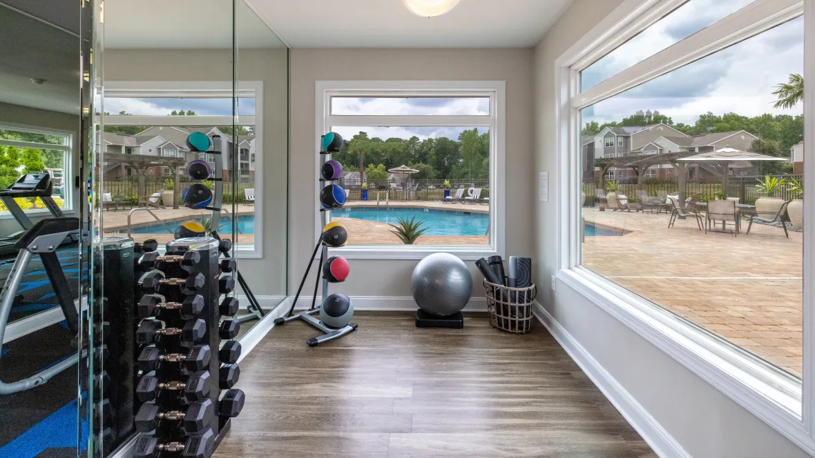 Sleek flooring for fluid movements in a space with stunning pool-deck views, a perfect, versatile area for yoga, stretching, or hand weights.